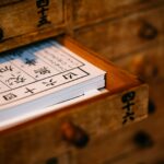 A wooden drawer filled with traditional Chinese acupuncture texts, symbolizing ancient wisdom and healing practices.
