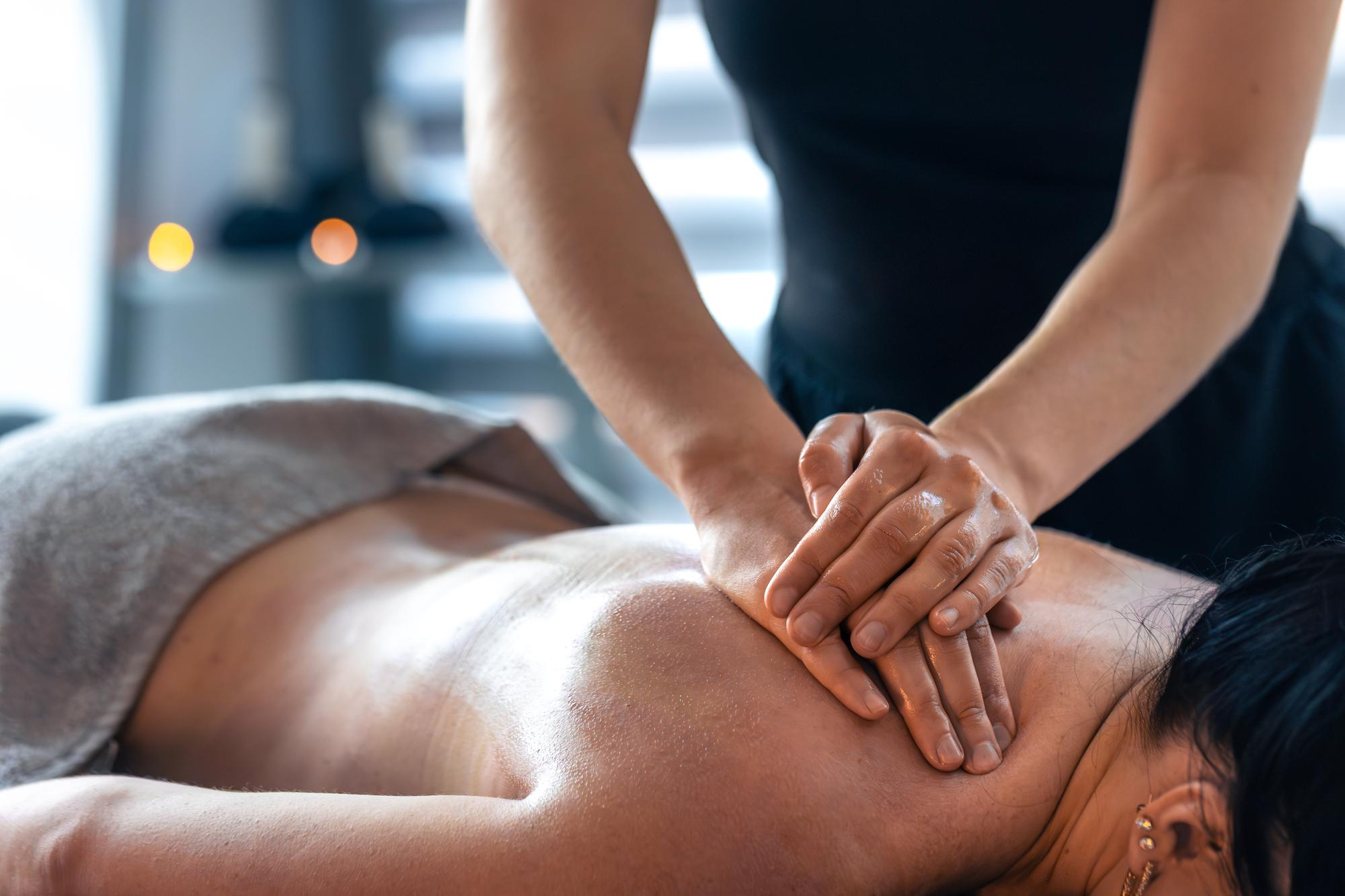 Massage therapist providing a back massage at London Holistic Health Clinic